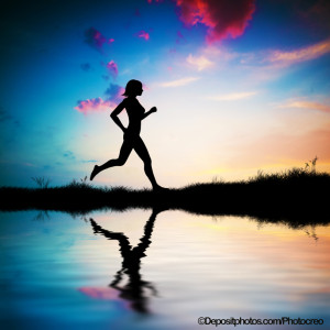 Silhouette of woman running at sunset
